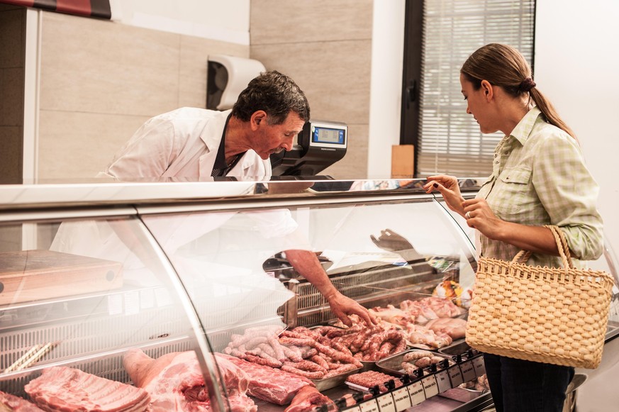 woman buying meat at the butcher shop