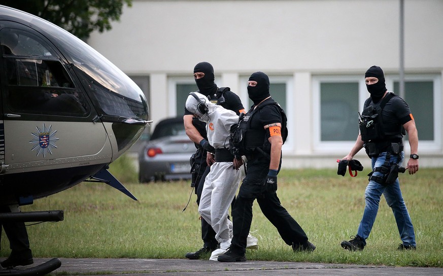 Wiesbaden: Ali B. wird von Beamten einer polizeilichen Spezialeinheit aus dem Justizzentrum zu einem Polizeihubschrauber gebracht und in eine JVA geflogen.Ali B. trägt einen Papieranzug.