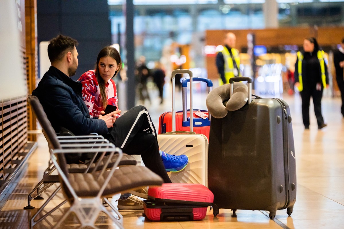 25.01.2023, Brandenburg, Schönefeld: Martin und Karoline aus Polen sitzen während eines Warnstreiks am Flughafen Berlin-Brandenburg BER. Sie wollten über Singapur nach Phuket in Thailand in den Urlaub ...