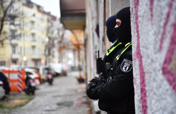 23.11.2023, Berlin: Polizeibeamte stehen bei einer Razzia in Berlin-Friedrichshain am Eingang eines Gebäudes. Sicherheitskräfte haben im Zusammenhang mit dem Verbot der Terrororganisation Hamas und de ...
