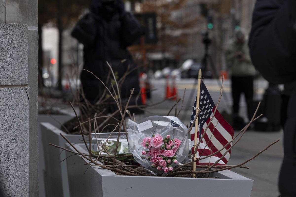 November 27, 2025, Washington, District Of Columbia, United States: A small memorial of flowers and an American flag is seen outside the Farragut West Metro station in Washington, D.C., on November 27 ...