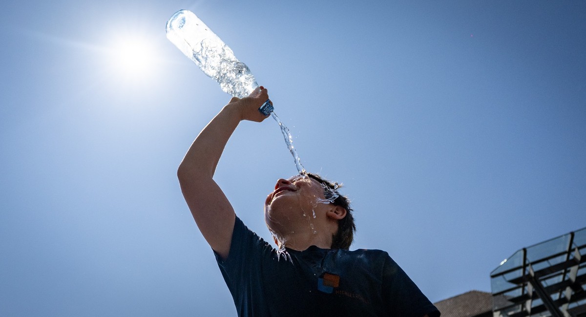 ARCHIV - 06.08.2025, Nordrhein-Westfalen, Bonn: Emil Goseberg kühlt sich auf dem Bonner Marktplatz mit einer Flasche Wasser ab. (zu dpa: «Krankenkasse: Mehr Menschen melden sich wegen Hitze krank») Fo ...