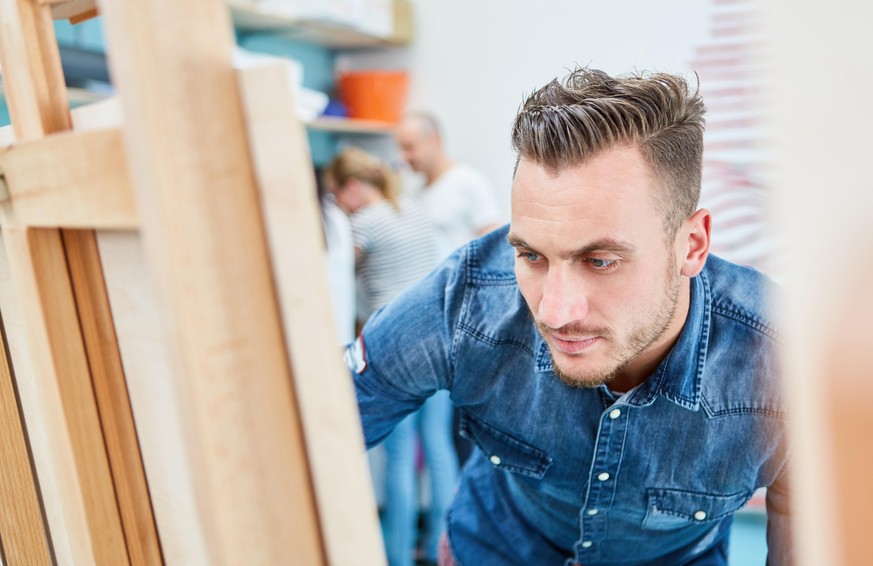 Maler lernt malen an Leinwand auf Staffelei im Atelier einer Kunsthochschule