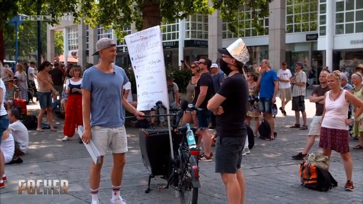 Der Pocher-Reporter (l.) unterhält sich mit einem Mann, der sich mit dem Alu-Hut vor 5G-Strahlen schützt.
