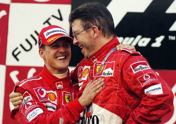 ARCHIV - 09.10.2004, Japan, Suzuka: ARCHIV - Der deutsche Formel-1-Pilot Michael Schumacher (l) jubelt in Suzuka nach seinem Sieg beim Gro