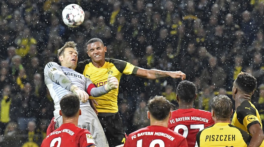 Dortmund's Manuel Akanji and Bayern goalkeeper Manuel Neuer, left, challenge for the ball during the German Bundesliga soccer match between Borussia Dortmund and Bayern Munich in Dortmund, Germany, Sa ...