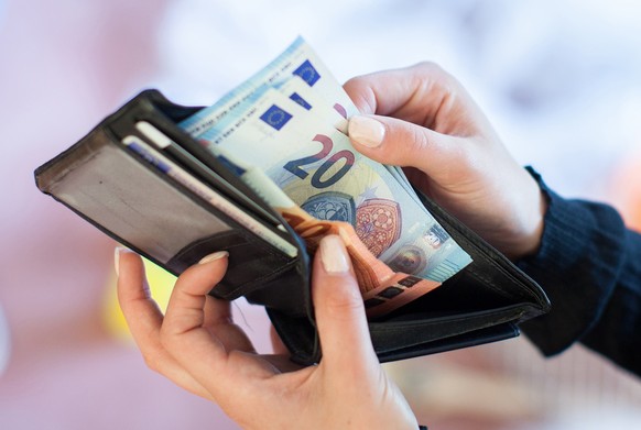 ARCHIV - 25.05.2016, Berlin: Eine Frau nimmt Banknoten aus einem Geldbeutel. Trotz Änderungen am ursprünglichen Regierungsentwurf für das geplante Bürgergeld steht die Einführung zum 1. Januar noch im ...