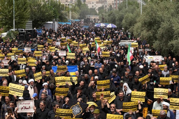 21.07.2023, Iran, Teheran: Gläubige tragen Anti-Amerika- und Anti-Israel-Plakate während eines Protests. Nach einer erneuten Koranschändung in Schweden sind im Iran zahlreiche Demonstranten auf die St ...