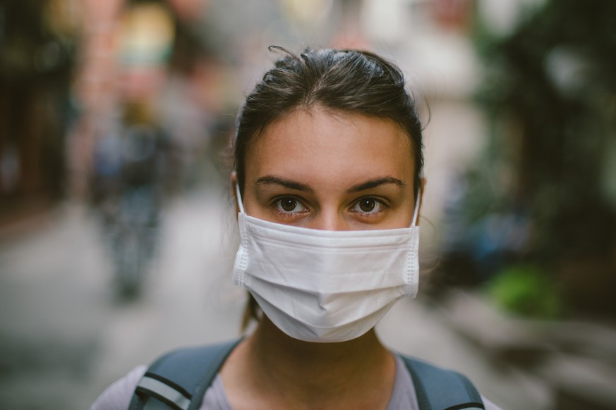 Eine Frau trägt eine einfach Atemschutzmaske.