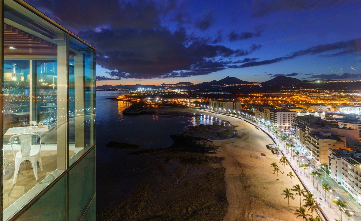 ARCHIV - Traumblick auf Strand und Stadt in Lanzarote: Solche Faktoren sollten die Hotelauswahl beeinflussen - nicht der Hotelname. Foto: Andreas Arnold/dpa/dpa-tmn - Honorarfrei nur für Bezieher des ...