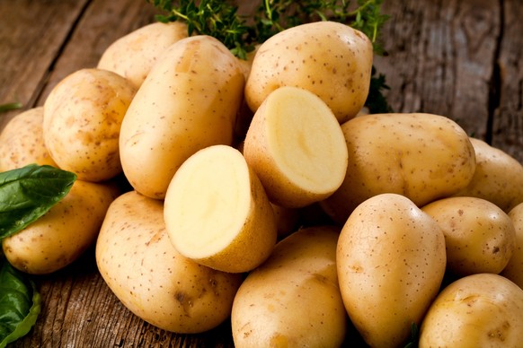 Fresh potatoes on wooden background