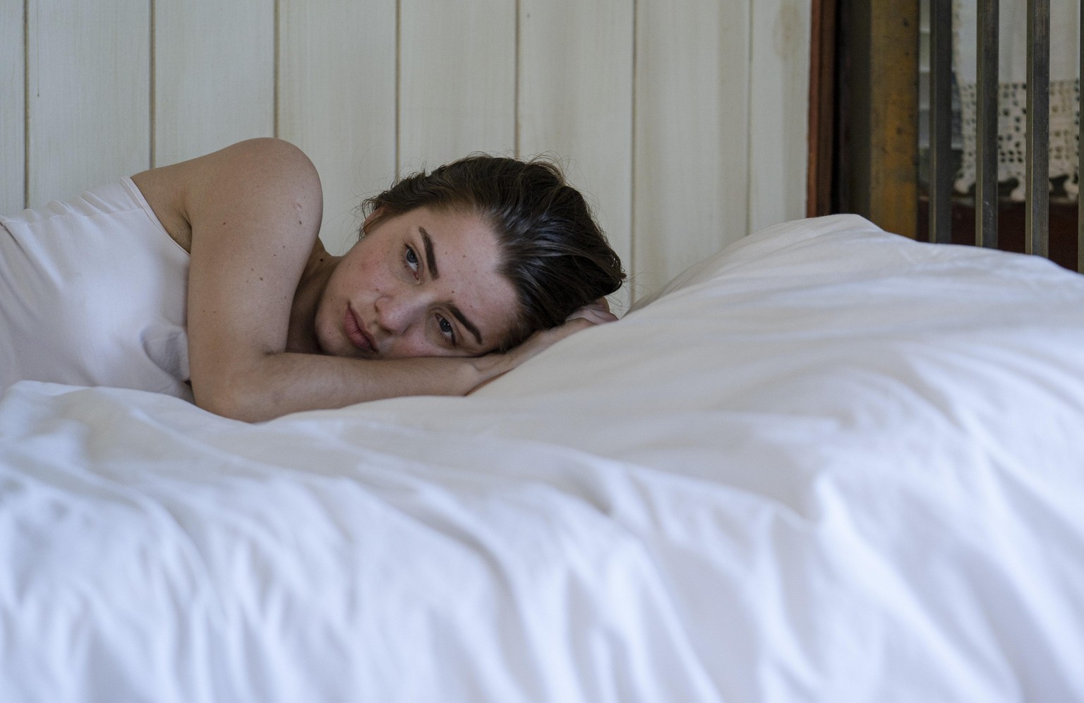 Young woman lying on bed || Modellfreigabe vorhanden