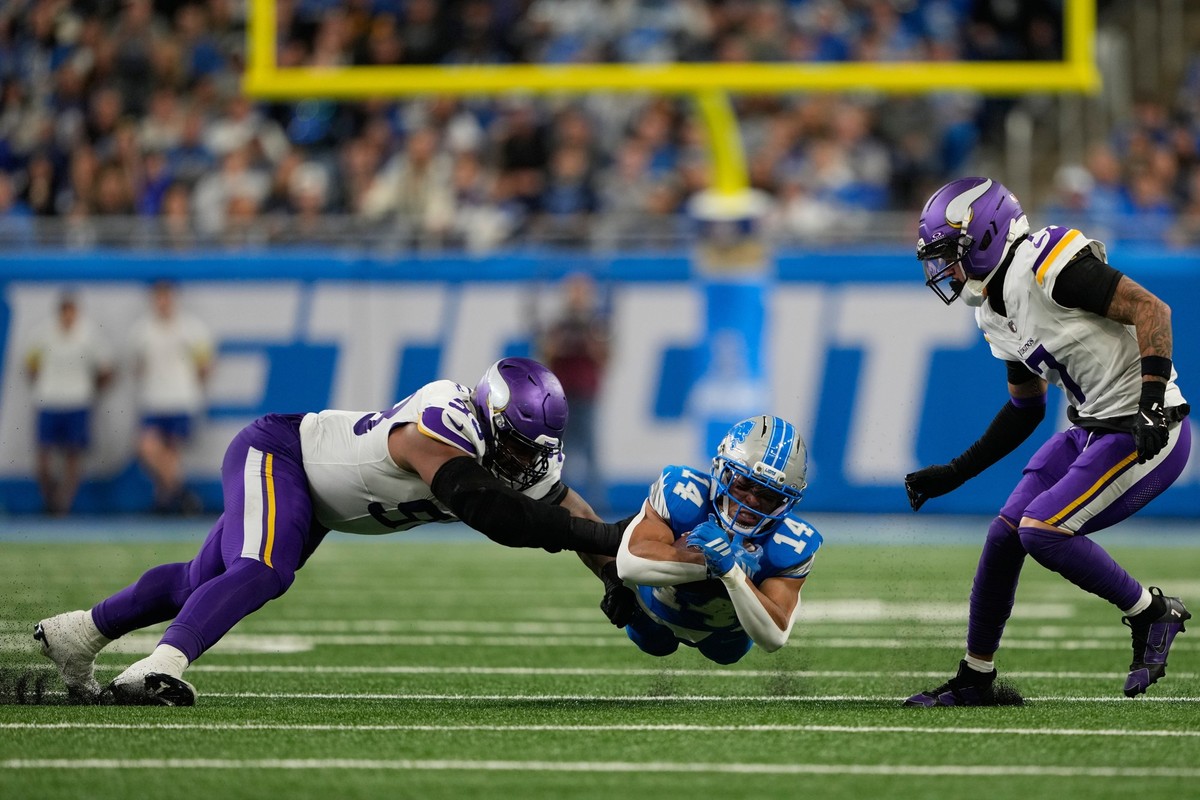 Detroit Lions wide receiver Amon-Ra St. Brown (14) catches a pass while defended by Minnesota Vikings defensive end Jonathan Allen (93), left, and cornerback Byron Murphy (7) during the second half of ...
