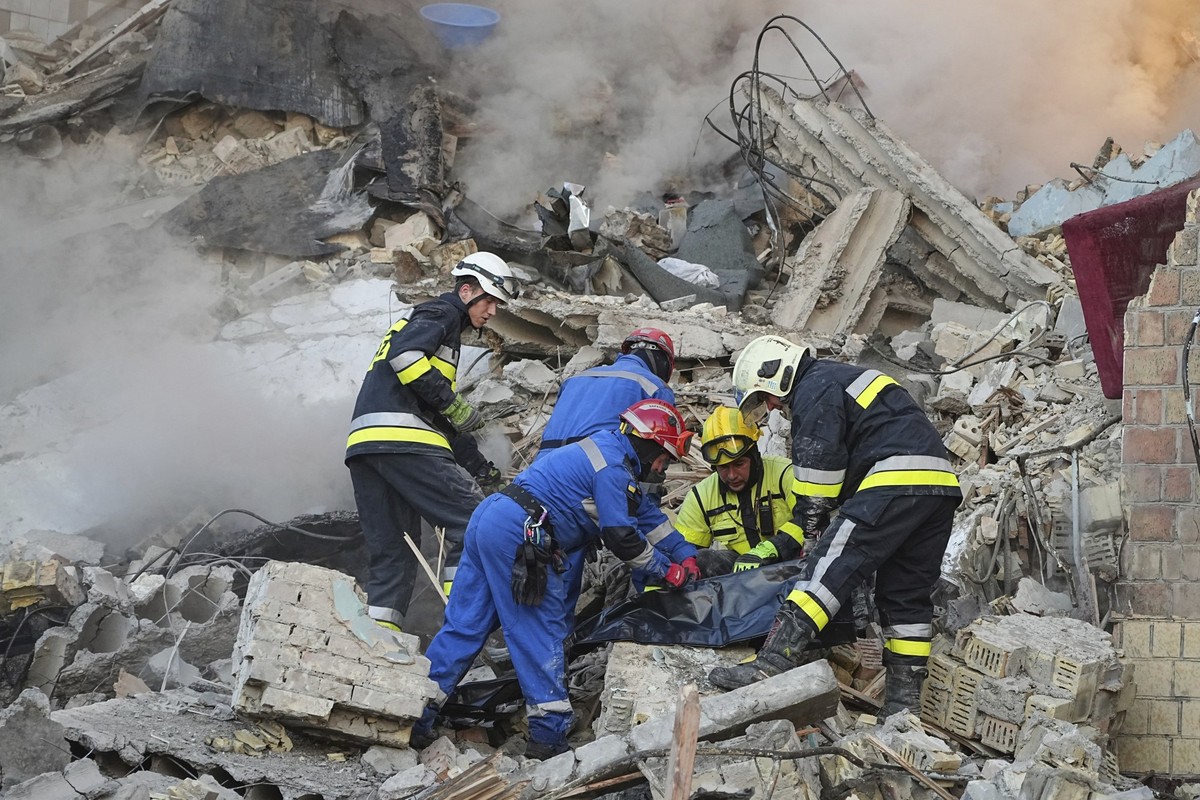 28.08.2025, Ukraine, Kiew: Feuerwehrleute bergen die Leiche eines Opfers nach einem russischen Angriff aus den Trümmern eines Gebäudes. Foto: Efrem Lukatsky/AP/dpa +++ dpa-Bildfunk +++