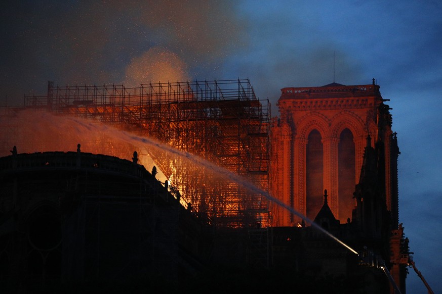 Firefighters use hoses as Notre Dame cathedral burns in Paris, Monday, April 15, 2019. A catastrophic fire engulfed the upper reaches of Paris&#039; soaring Notre Dame Cathedral as it was undergoing r ...