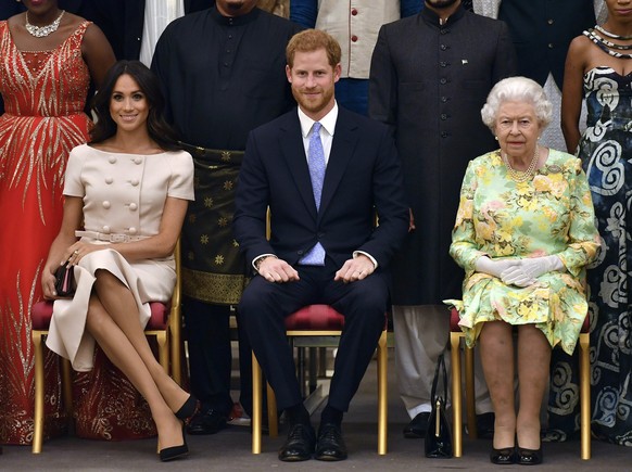 FILE - In this Tuesday, June 26, 2018 file photo, Britain's Queen Elizabeth, Prince Harry and Meghan, Duchess of Sussex pose for a group photo at the Queen's Young Leaders Awards Ceremony at Buckingha ...