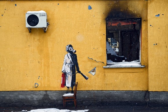 HOSTOMEL, UKRAINE - NOVEMBER 26, 2022 - The mural by England-based street artist Banksy depicts a woman in a gas mask standing on a chair and holding a fire extinguisher, Hostomel, Kyiv Region, northe ...