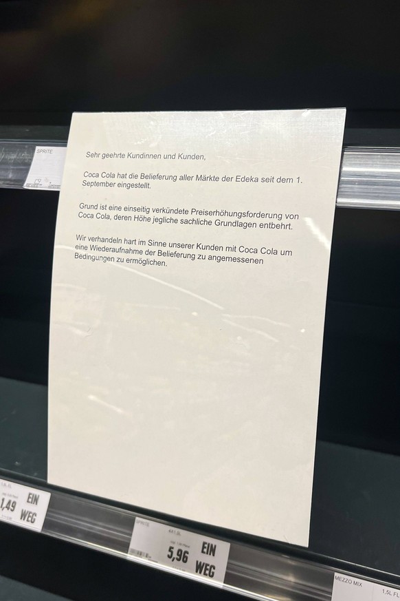 Edeka weist angesichts eines leeren Regals darauf hin, dass Coca-Cola die Lieferung eingestellt hat.