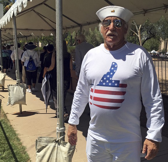 Louis Albin, an artist in Phoenix and Navy veteran, displays his custom-made T-shirt, as he waited in line for the public viewing of the late Sen. John McCain Wednesday, Aug. 29, 2018, outside the Ari ...