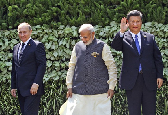 FILE- Russian President Vladimir Putin, Indian Prime Minister Narendra Modi, and Chinese President Xi Jinping gather for a group photo at the start of the BRICS Summit in Goa, India, Sunday, Oct. 16,  ...