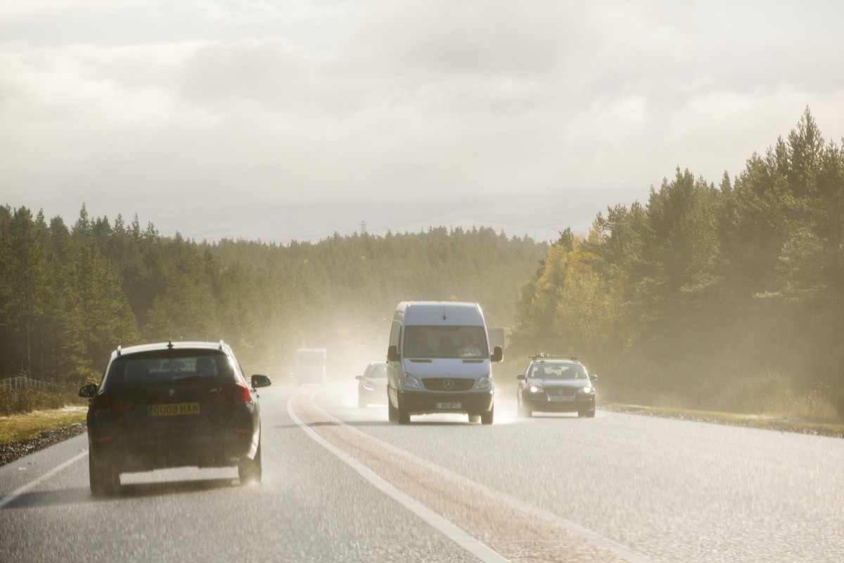 A drivers eye view of spray on the road caused by cars driving on a wet A9, Scotland, UK. xkwx Scotland UK Autumn snow cold car driver driving travel car touring windscreen road driving conditions win ...