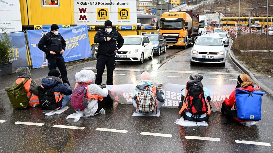 ARCHIV - 31.01.2022, Baden-Württemberg, Stuttgart: Klimaaktivisten blockieren auf der Bundesstraße 10 zur Hauptverkehrszeit den Verkehr. In der Debatte um zwei Klimaschützer, die wegen einer Fernreise ...