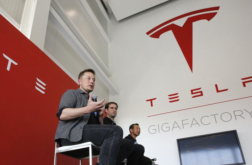FILE - In this July 26, 2016, file photo, Elon Musk, CEO of Tesla Motors Inc., left, discusses the company&#039;s new Gigafactory in Sparks, Nev. Shareholders of electric car and solar panel maker Tes ...