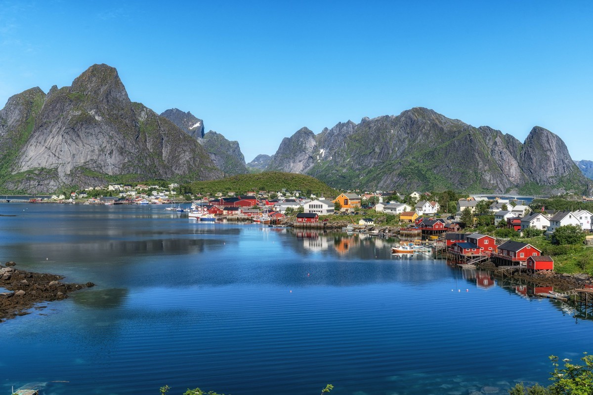 Das Fischerdorf Reine auf den Lofoten mit Blick auf den Arktischen Ozean und die rote Rorbu. Berühmtes Touristenziel auf den Lofoten, Norwegen Reine fishing village in Lofoten view with the view of th ...