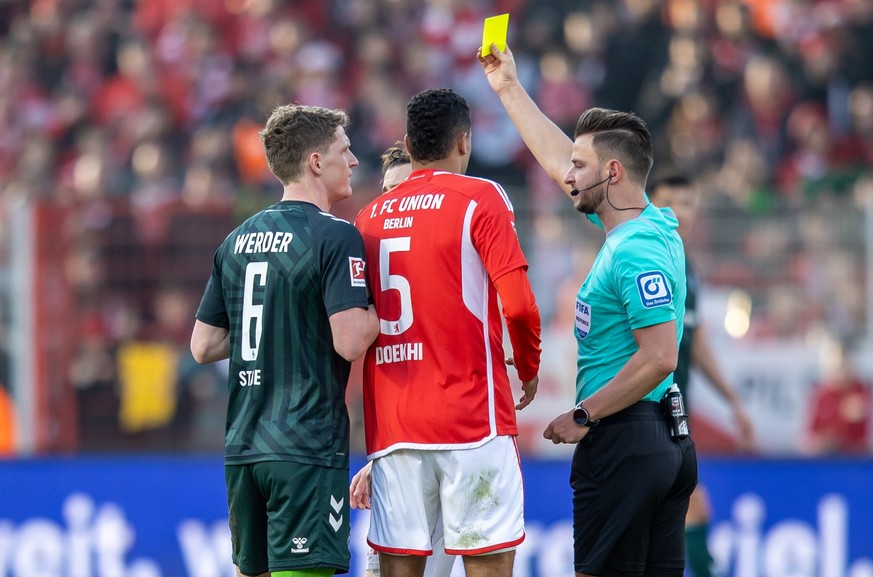 16.03.2024, Berlin: Fußball: Bundesliga, 1. FC Union Berlin - Werder Bremen, 26. Spieltag, An der Alten Försterei. Jens Stage (l) von Werder Bremen erhält die Gelbe Karte von Schiedsrichter Daniel Sch ...