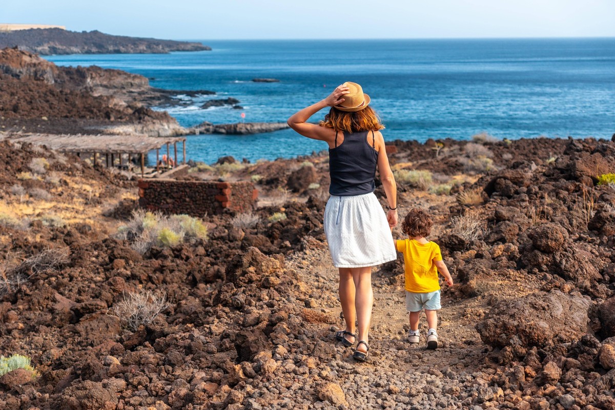 Mutter und Sohn im Urlaub beim Spaziergang auf einem Weg entlang des Strandes von Tacoron auf El Hierro, Kanarische Inseln *** Mother and Son at Holiday at Walking tour at a Path along of Beach from T ...
