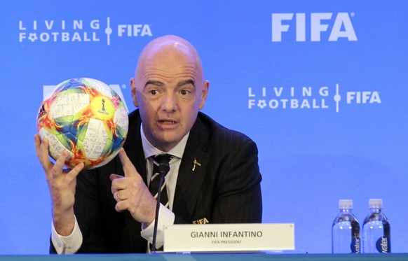 FILE - FIFA President Gianni Infantino holds a soccer ball as he speaks during a press conference after the FIFA Council Meeting, Friday, March 15, 2019, in Miami. FIFA is moving more than 100 jobs fr ...