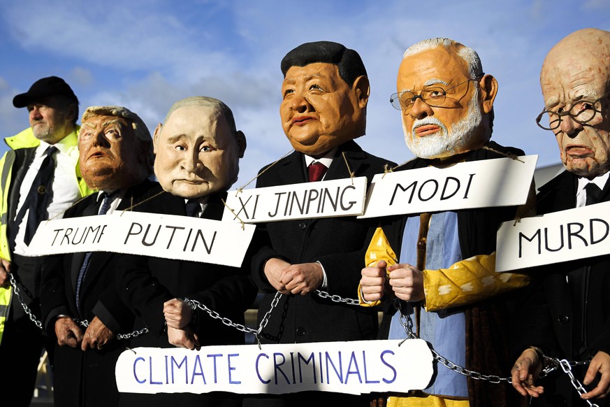 Cop26 - Glasgow Activists wearing world leader heads protest on south bank of the river Clyde across from the Scottish Event Campus on day five of the COP 26 United Nations Climate Change Conference o ...