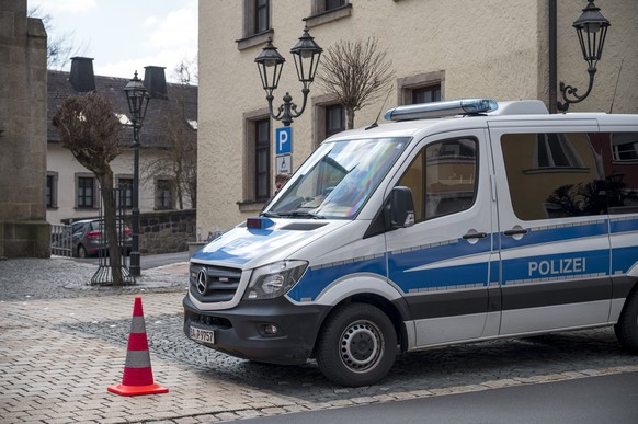 05.04.2023, Bayern, Wunsiedel: Ein Einsatzwagen der Polizei sperrt die Straße zu einem Kinder- und Jugendhilfezentrum ab. In der Einrichtung war am Vortag eine Zehnjährige tot in einem Zimmer gefunden ...