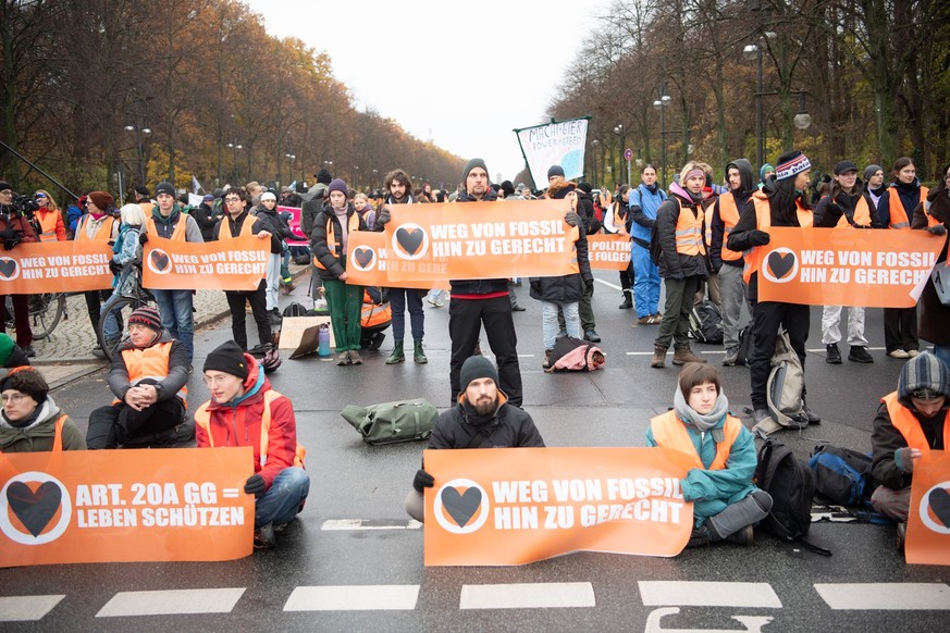 ARCHIV - 25.11.2023, Berlin: Aktivisten der Klimaschutzgruppe &quot;Letzte Generation&quot; und anderer Gruppierungen blockieren die Straße des 17. Juni. Das Deutsche Institut für Menschenrechte (DIMR ...