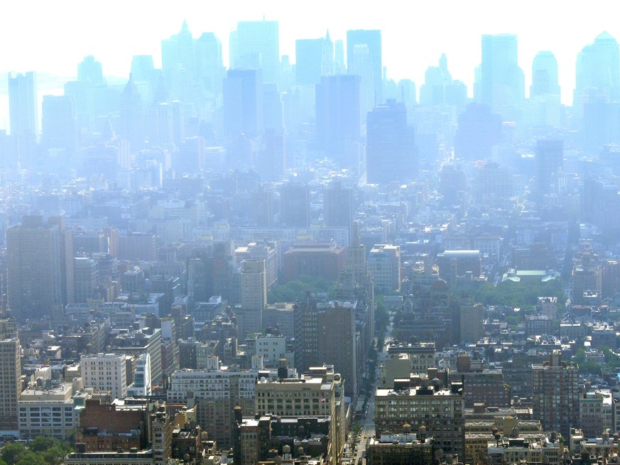 Panoramic high angle view of Manhattan showing rows and rows of skyscrapers disappearing in the distance on a late afternoon and under a heavy blanket of smog and haze due to pollution