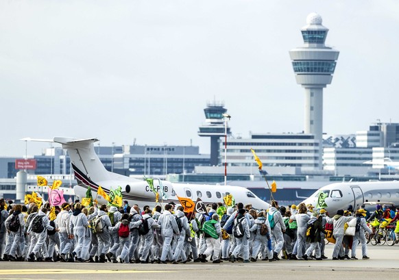 dpatopbilder - 05.11.2022, Niederlande, Amsterdam: Aktivisten verschiedener Umweltvereine führen die Protestaktion «SOS für das Klima» auf dem Flughafengelände vom Flughafen Schiphol durch. Unter ande ...