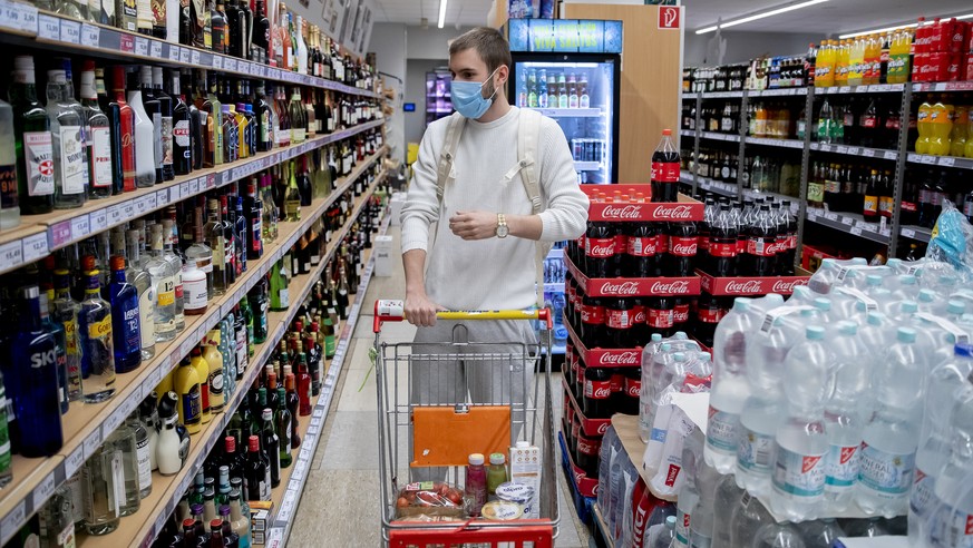 28.04.2020, Berlin: Ein Kunde geht in einem Supermarkt in Berlin-Wilmersdorf mit Mund-Nasen-Schutz einkaufen. Foto: Christoph Soeder/dpa +++ dpa-Bildfunk +++