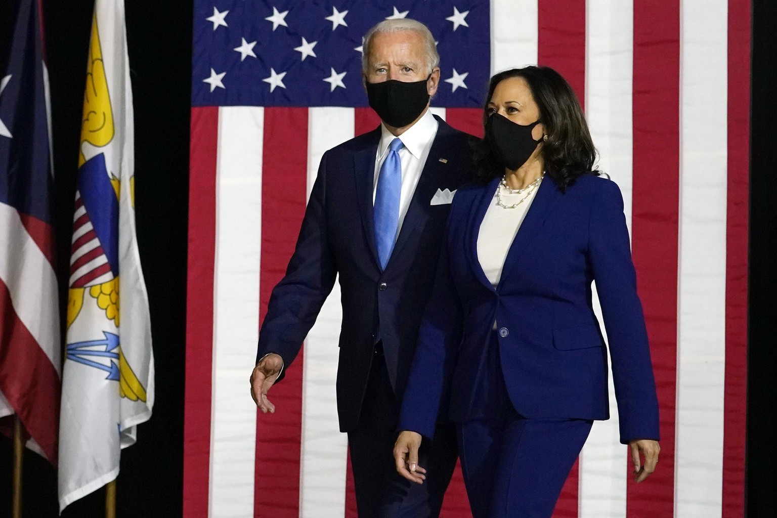 12.08.2020, USA, Wilmington: Joe Biden (l), designierter Präsidentschaftskandidat der US-Demokraten, und Kamala Harris, Senatorin in Kalifornien, kommen zu einer Pressekonferenz. Biden zieht mit der k ...