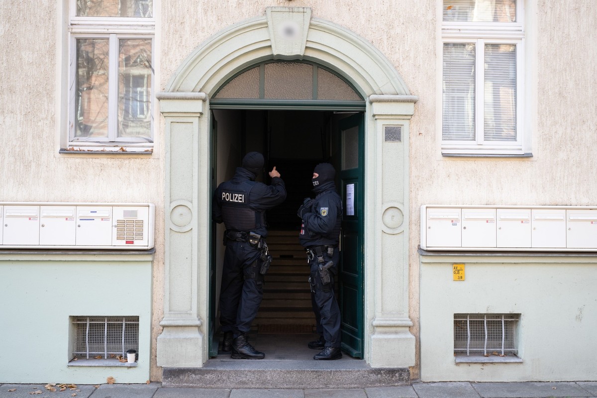 05.11.2024, Sachsen, Dresden: Polizisten stehen während einer Razzia gegen mutmaßliche Rechtsextreme in einem Hauseingang im Dresdner Stadtteil Cotta. Die Bundesanwaltschaft hat acht mutmaßliche Recht ...