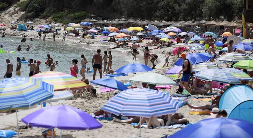 14.08.2022, Spanien, Capdepera: Menschen schwimmen und sonnen sich am Strand Cala Ratjada auf Mallorca. Noch immer herrschen hier hohe Temperaturen und Hitzewarnungen. Foto: Clara Margais/dpa +++ dpa- ...