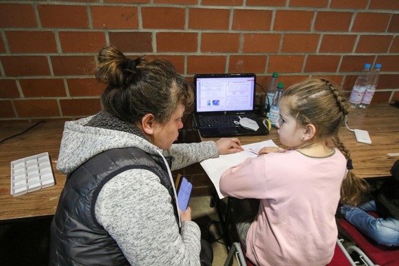 Oksana (43) aus der Ukraine gibt ihrer Tochter Jana (10) Unterricht am Laptop: Alltag in der zur Notunterkunft umfunktionierten Hessenhalle in Alsfeld. In der Stadt im Vogelsbergkreis befindet sich ei ...
