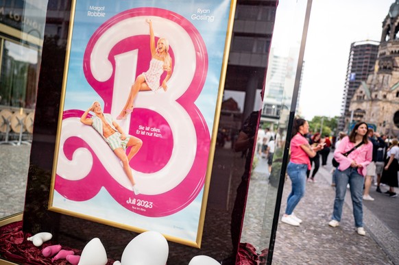 ARCHIV - 13.08.2023, Berlin: Menschen gehen mit Rosa Klamotten in den das Kino Zoo Palast. Der Barbie Film ist zu einem Lebensgefühl geworden. (zu dpa: &quot;Ein pinkes Outfit ist das neue Lebensgefüh ...