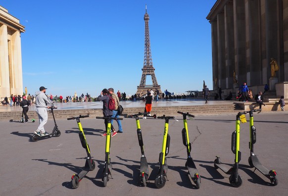 ARCHIV - 14.05.2019, Frankreich, Paris: E-Tretroller stehen zum Mieten auf der Place du Trocadero bereit - im Hintergrund ist der Eiffelturm zu sehen. (zu dpa: E-Scooter-Verleiher in Paris versch�rfen ...