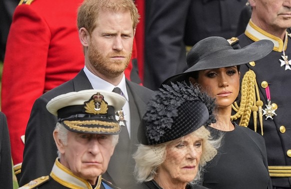 FILE - Britain&#039;s King Charles III, from bottom left, Camilla, the Queen Consort, Prince Harry and Meghan, Duchess of Sussex watch as the coffin of Queen Elizabeth II is placed into the hearse fol ...
