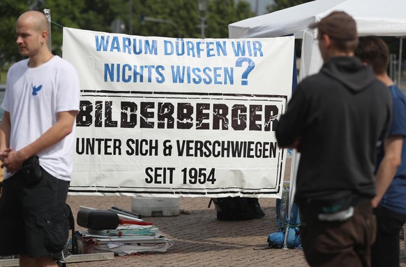 DRESDEN, GERMANY - JUNE 09: Peace activists with a banner that reads: &quot;Why aren&#039;t we allowed to know? Bilderberger - amongst themselves and silent since 1954&quot; maintain a vigil near the  ...
