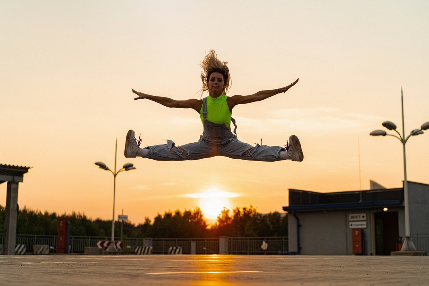 Woman in a split jump against the background of a sunset. California City, California, United States CR_YUKI230309-1148817-01 ,model released, Symbolfoto