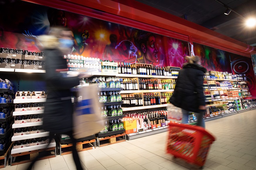 ARCHIV - 17.11.2020, Hamburg: Kunden sind vor dem Regal mit alkoholischen Getr