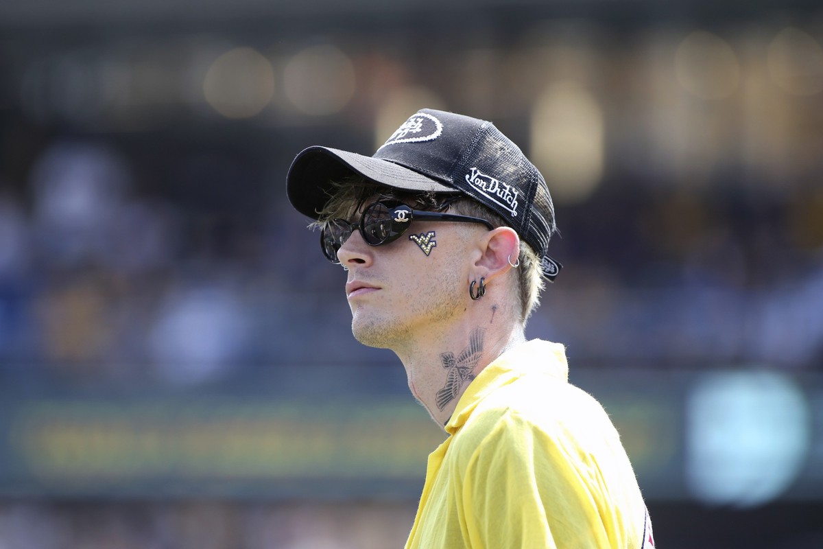 Machine Gun Kelly watches the scoreboard from the sidelines during the first half of the Penn State at West Virginia NCAA college football game in Morgantown, W.Va., Saturday, Aug. 31, 2024. (AP Photo ...