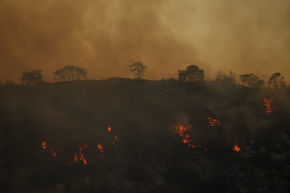 17.07.2023, Griechenland, Loutraki: Flammen und Rauch steigen von einem Waldbrand auf einem Berg in der Nähe von Loutraki auf. Nach einer längeren Trockenperiode sind im Großraum der griechischen Haup ...