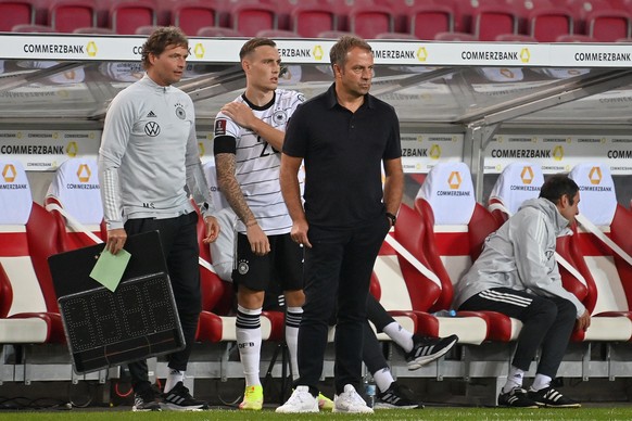 David Raum (M.) wird in der 83. Minute gegen Armenien von Bundestrainer Hansi Flick (r.) eingewechselt. 